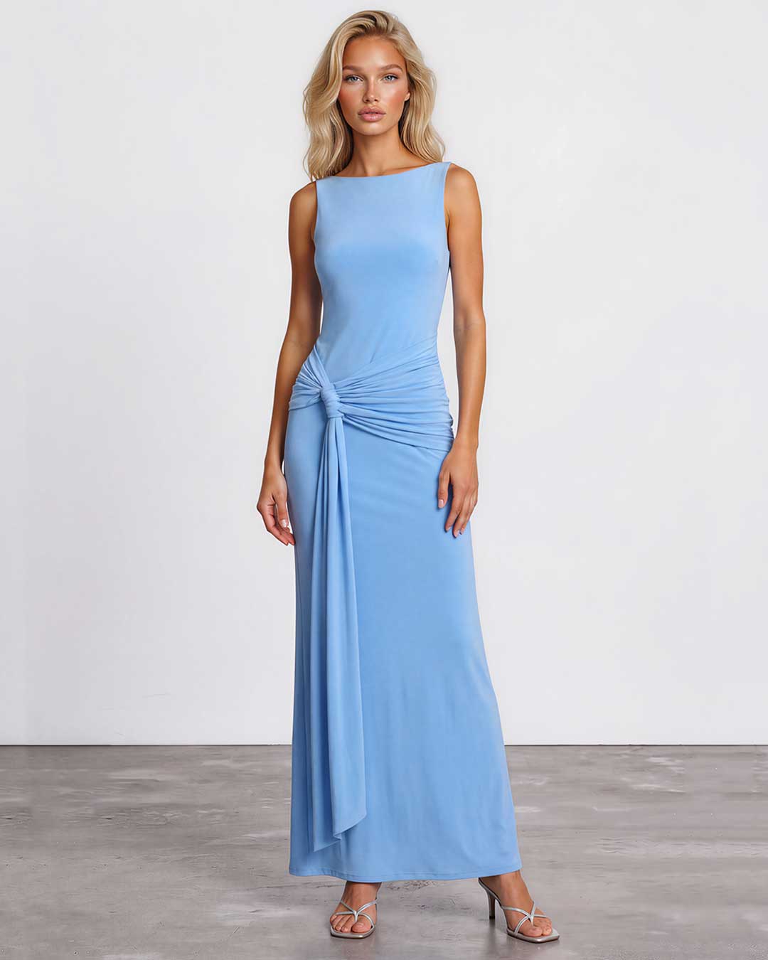 Model wearing a blue sleeveless maxi dress with gathered waist and draped tie